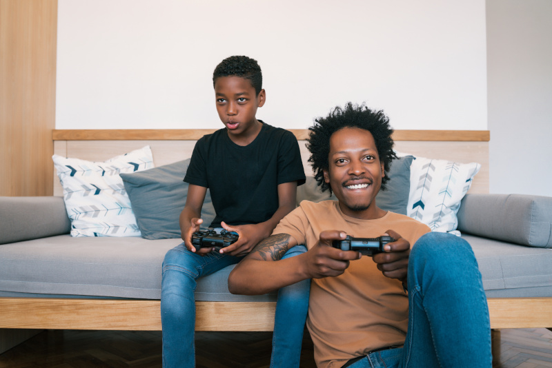 Broadband Providers man and son playing with computer games console